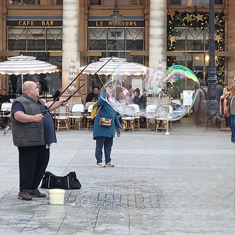 Un homme fait de gigantesques bulles de savon sur une place parisienne. Barbibul est l’un des personnages de la célèbre série de livres et de dessins animés Barbapapa