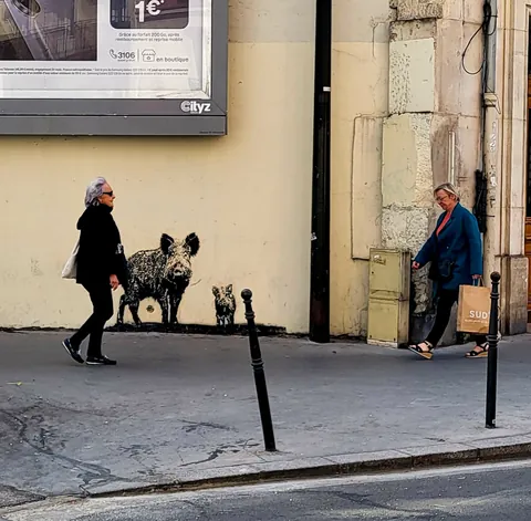 Une passante devant une sculpture de sanglier, rue piétonne