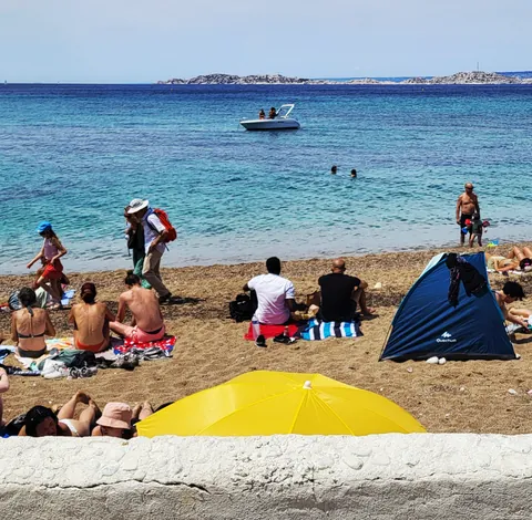 Une plage avec un parasol jaune et une tente bleue
