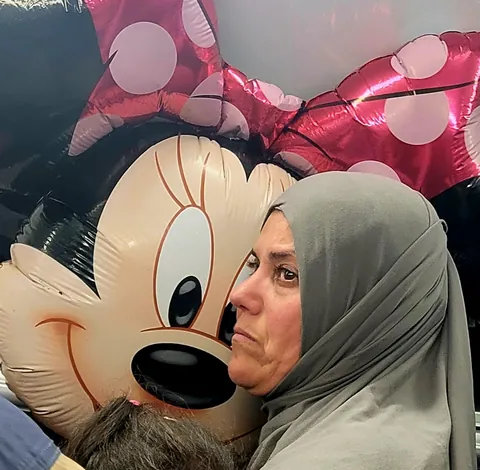 Une femme voilée qui serre un ballon Minnie
