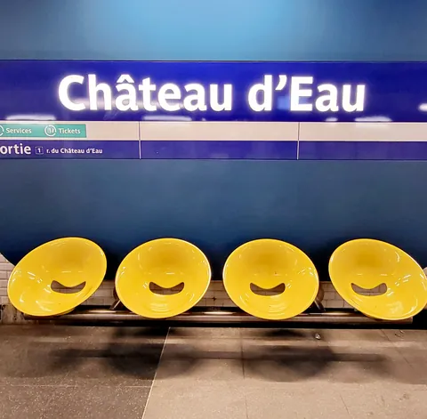 Le panneau « Château d’Eau » au-dessus de sièges jaunes du métro