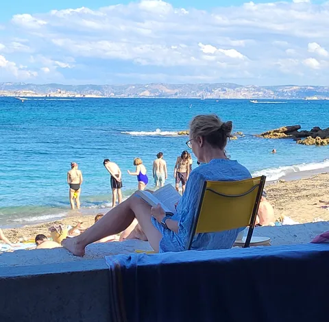Une femme qui lit en transat face à la mer