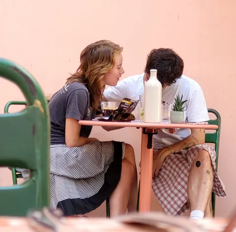 Un couple attablé qui se parle à l’oreille