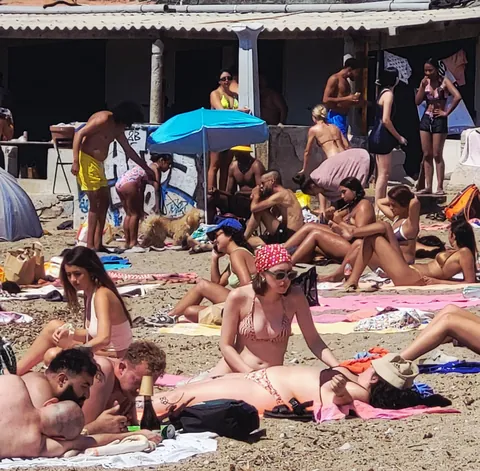 Une plage bondée de baigneurs allongés