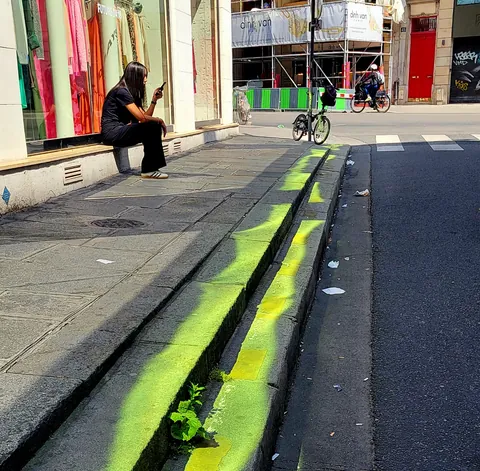 Une coulée de peinture fluo le long d’un trottoir