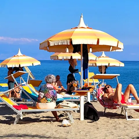 Scène de plage avec des transats et parasols colorés