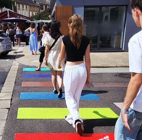 Des passants sur un passage piéton aux couleurs de l’arc-en-ciel