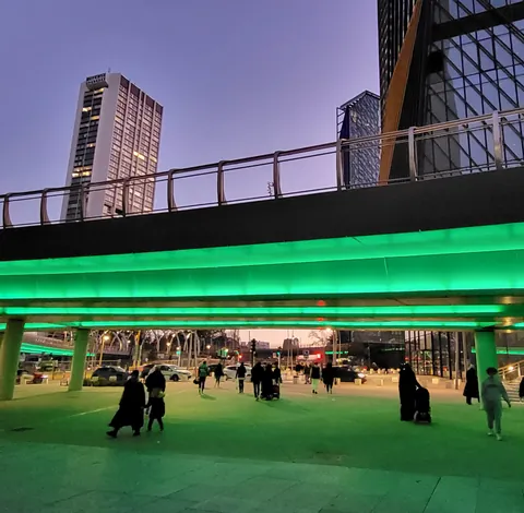 Une passerelle urbaine baignée de lumière verte fluo
