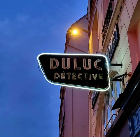 L’enseigne « Duluc Détective » au coin d’une rue