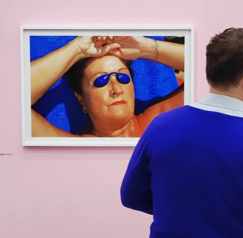 Un homme devant une photo d’une femme en lunettes de soleil