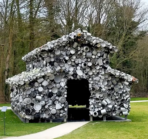 Une cabane entièrement recouverte de casseroles et de gamelles en métal, dans un parc