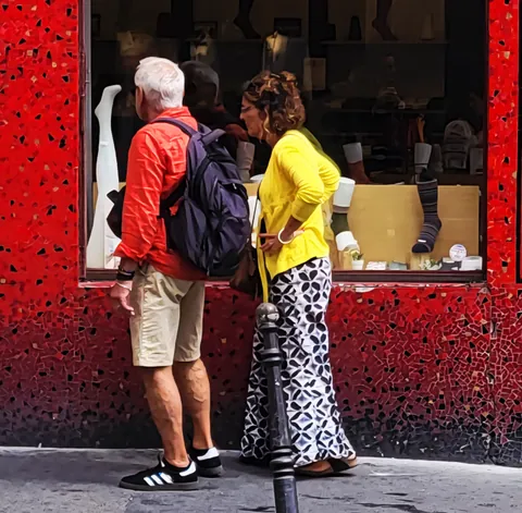 Un couple en rouge et jaune devant une vitrine rouge