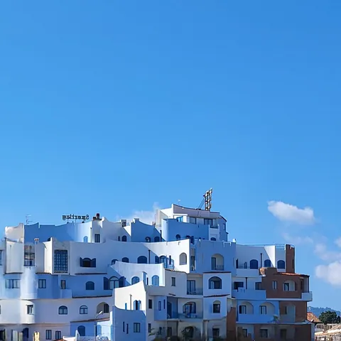 Un immeuble d’habitation bleu et blanc devant un ciel bleu. Film d’animation de 1986, le Château dans le ciel est réalisé par Hayao Miyazaki