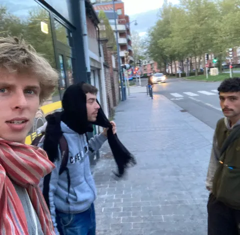 Trois jeunes dans la rue, l’un fait la grimace