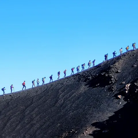 File de marcheurs en ligne sur la crête d’une montagne, comme dans le jeu d’arcade Lemmings. Dans Lemmings, créé en 1991, le joueur doit guider des dizaines de lemmings, minuscules créatures écervelées, dans des niveaux alambiqués truffés de dangers mortels.