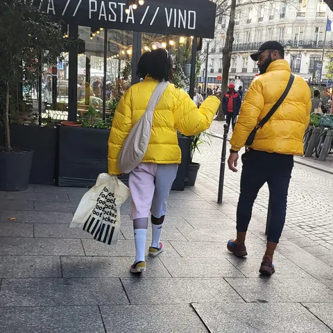 Deux personnes en doudounes jaunes dans les rues de Paris