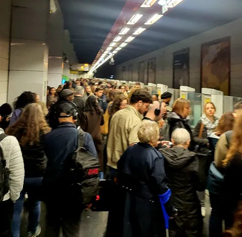 Une foule serrée dans un couloir de gare