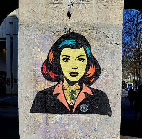 Un collage pop d’une femme au visage jaune sur un mur
