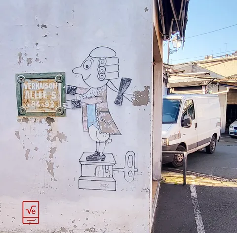 Un dessin de Pinocchio sur un mur à côté d’une plaque de rue