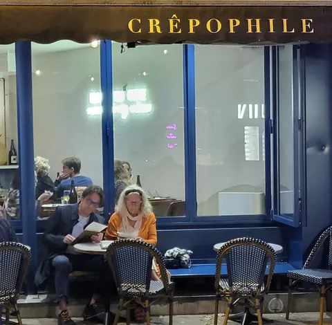 Des clients en terrasse sous l’enseigne « Crêpophile »