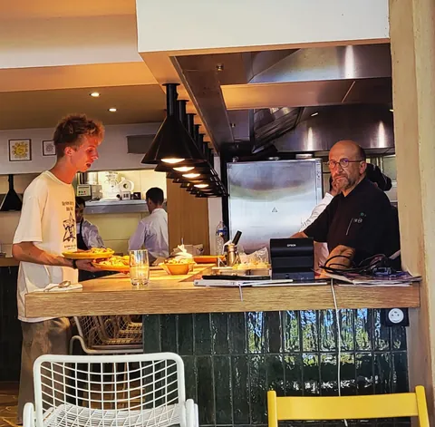 Deux cuisiniers derrière le comptoir d’un restaurant