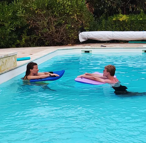 Deux nageurs sur des matelas gonflables dans une piscine bleue