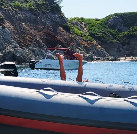 Des jambes qui dépassent d’un bateau pneumatique, les pieds en l’air