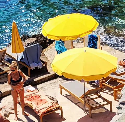 Des parasols jaunes au-dessus de transats, vus d’en haut