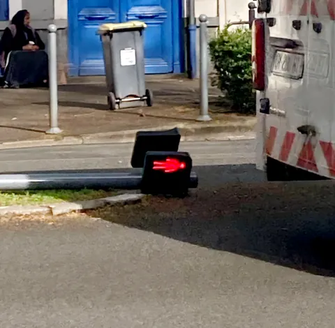Un feu de signalisation couché sur le trottoir