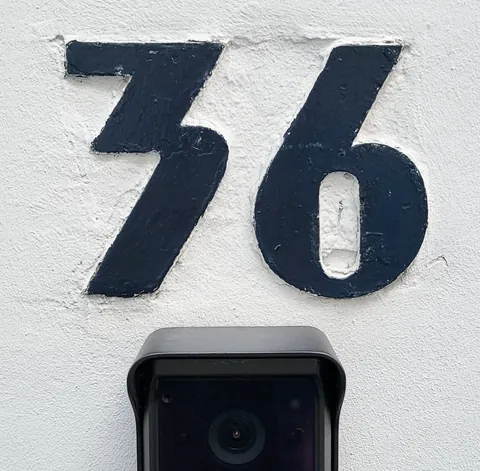 Un grand numéro 36 peint au-dessus d’une caméra de surveillance