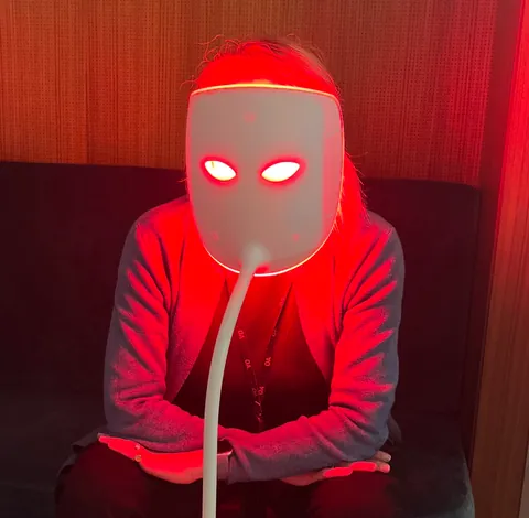 Une personne sous un masque LED rouge aux yeux lumineux
