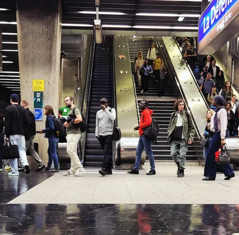 Un escalator de gare bondé, vu de face