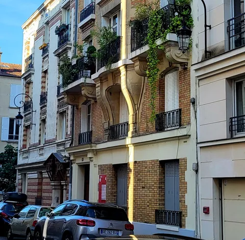 Une gouttière qui coupe une façade d’immeuble en deux