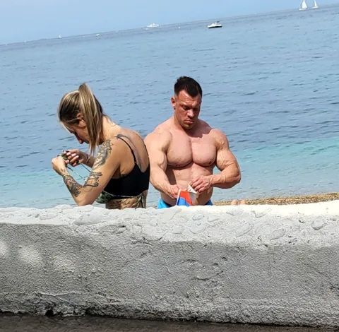 Un couple musclé et tatoué au bord de l’eau