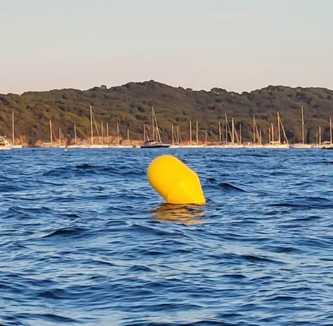 Une bouée jaune qui flotte dans une baie