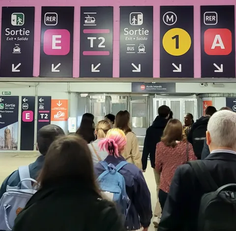 Des panneaux de RER et de métro au-dessus d’une foule