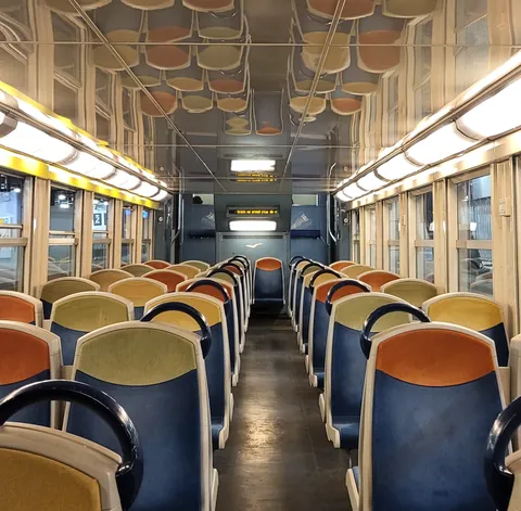 L’intérieur d’un vieux wagon de train, sièges orange et bleus