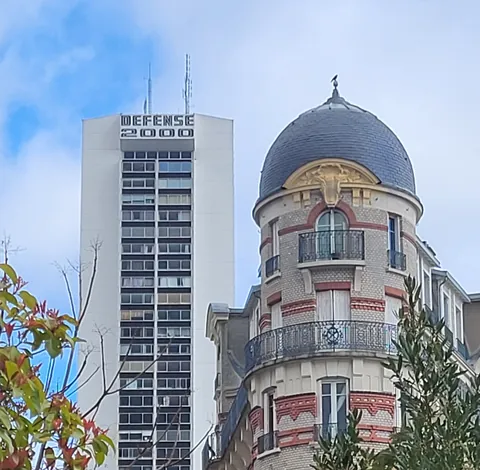 Une tour des années 70 qui dépasse derrière un immeuble ancien à coupole