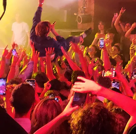 Une foule de concert qui porte un spectateur à bout de bras