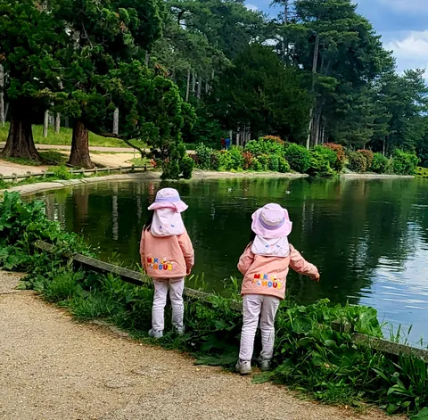 Deux petites filles en rose au bord d’un lac