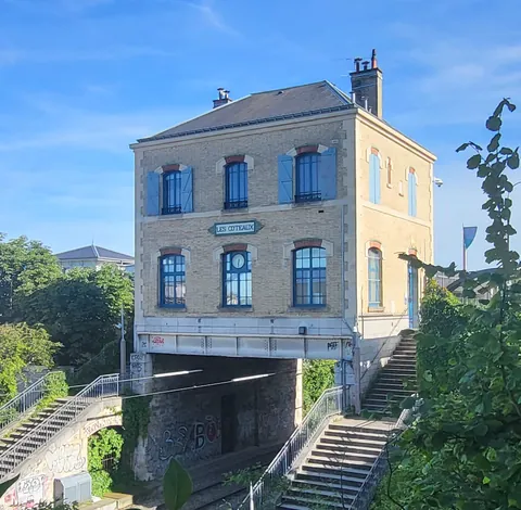 Une maison ancienne posée au-dessus d’un passage vide, au bord d’un escalier
