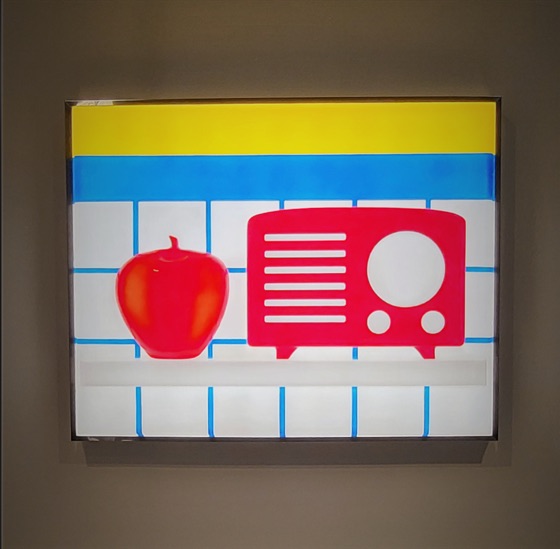 Une pomme et une radio rouges peintes sur un panneau lumineux