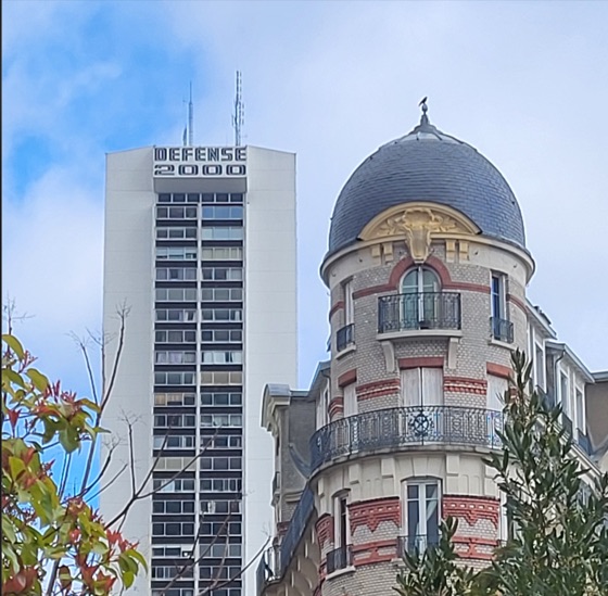 Une tour des années 70 qui dépasse derrière un immeuble ancien à coupole